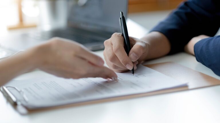 woman is signing documents