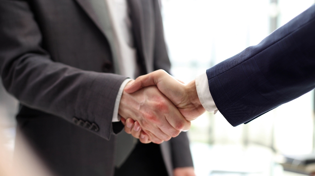 two men in suits are shaking hands