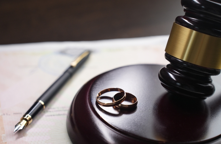 Judge's gavel, wedding rings and pen