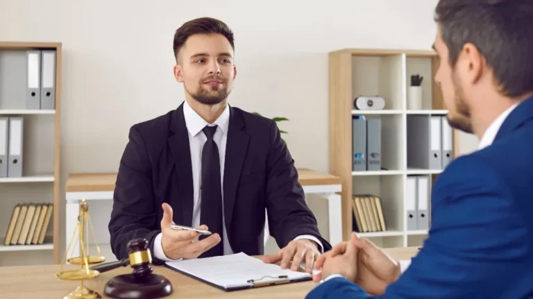 Two men in business suits engaged in a discussion in a professional office setting.